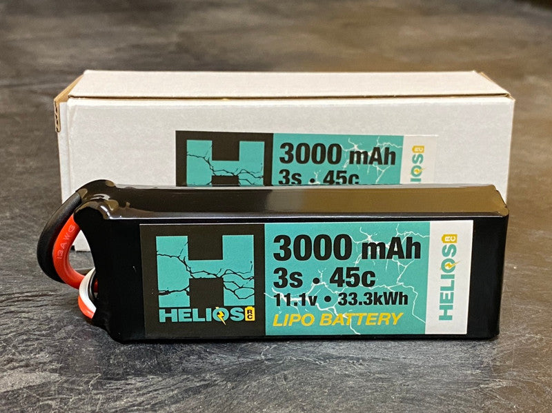 A Helios RC 3S 3000 MAH 45C LIPO battery pack with a XT60 connector, placed next to its packaging box.