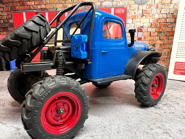 FCX24 Power Wagon with large black wheels and red rims on a concrete floor. -1