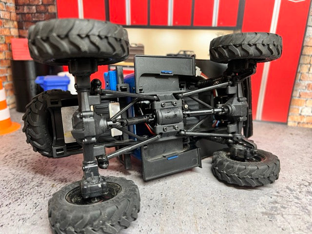 Black off-road vehicle chassis with large tires on a concrete floor FCX24 Power Wagon. -1