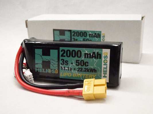 A Helios RC 3S 2000 mAh 50C Lipo battery with a Deans-style connector, shown alongside its packaging.