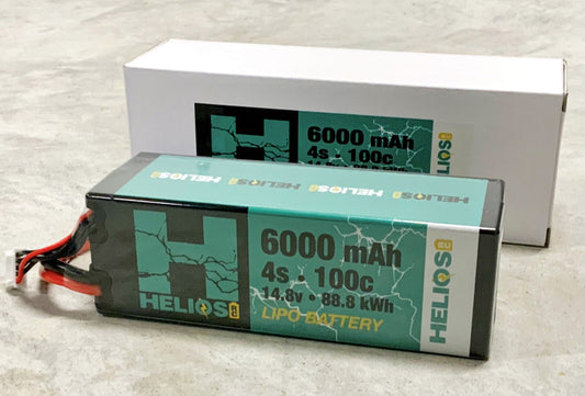 Two stacked rectangular lithium polymer battery packs with green and black coloring and branding details, indicating a capacity of 6000 mAh and 100C discharge rate.