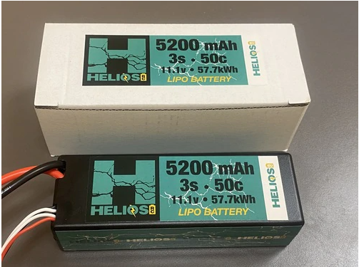 A Helios RC 3S 5200 mAh 50c Lipo battery with Deans connector, displayed next to its packaging box.